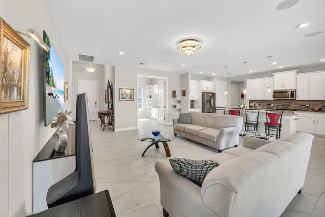a living room with furniture and kitchen view
