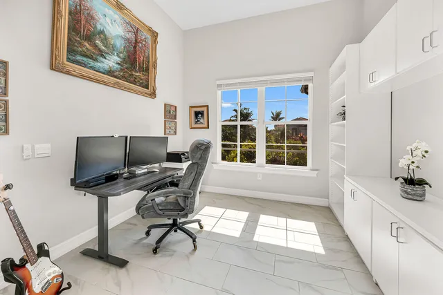a view of a workspace with furniture and a window