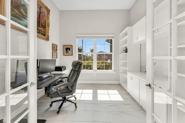 a view of a workspace with furniture and a window