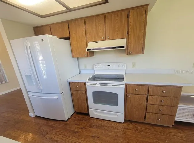 a kitchen with a refrigerator sink and cabinets