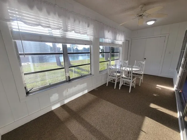 a dining room with furniture and a large window