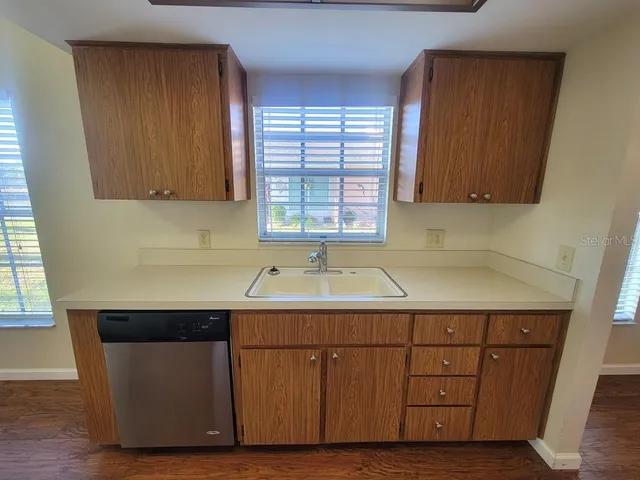 a utility room with a sink window and cabinets