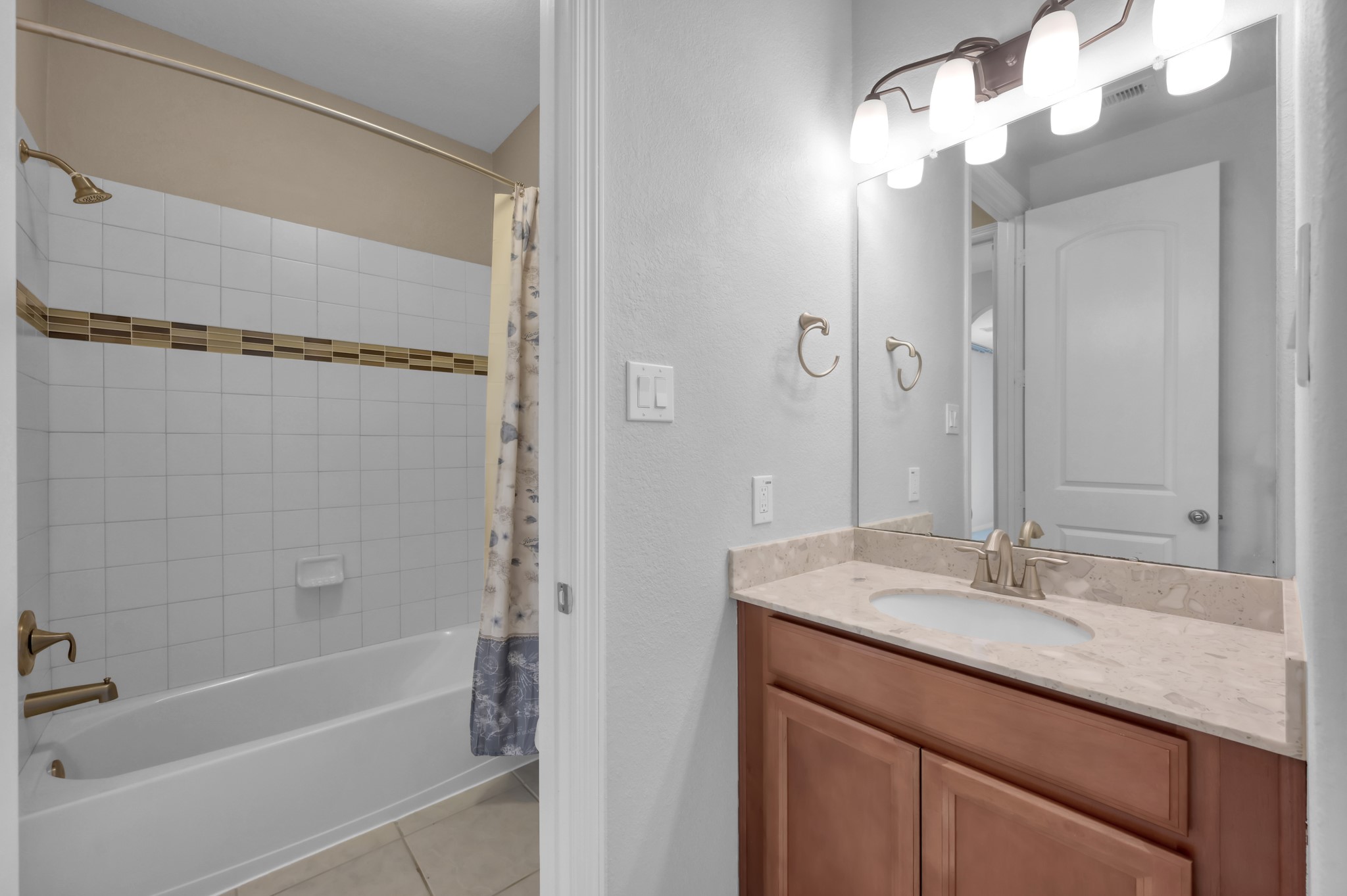 23219 Belted Kingfisher Trail Spring, TX 77389 - Photo 26 of 43 a bathroom with a granite countertop sink a mirror and a bathtub