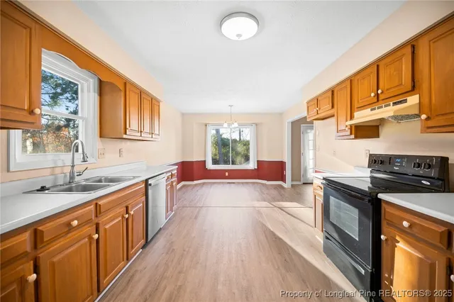 a kitchen with stainless steel appliances granite countertop a stove a sink and a granite counter tops with wooden floors