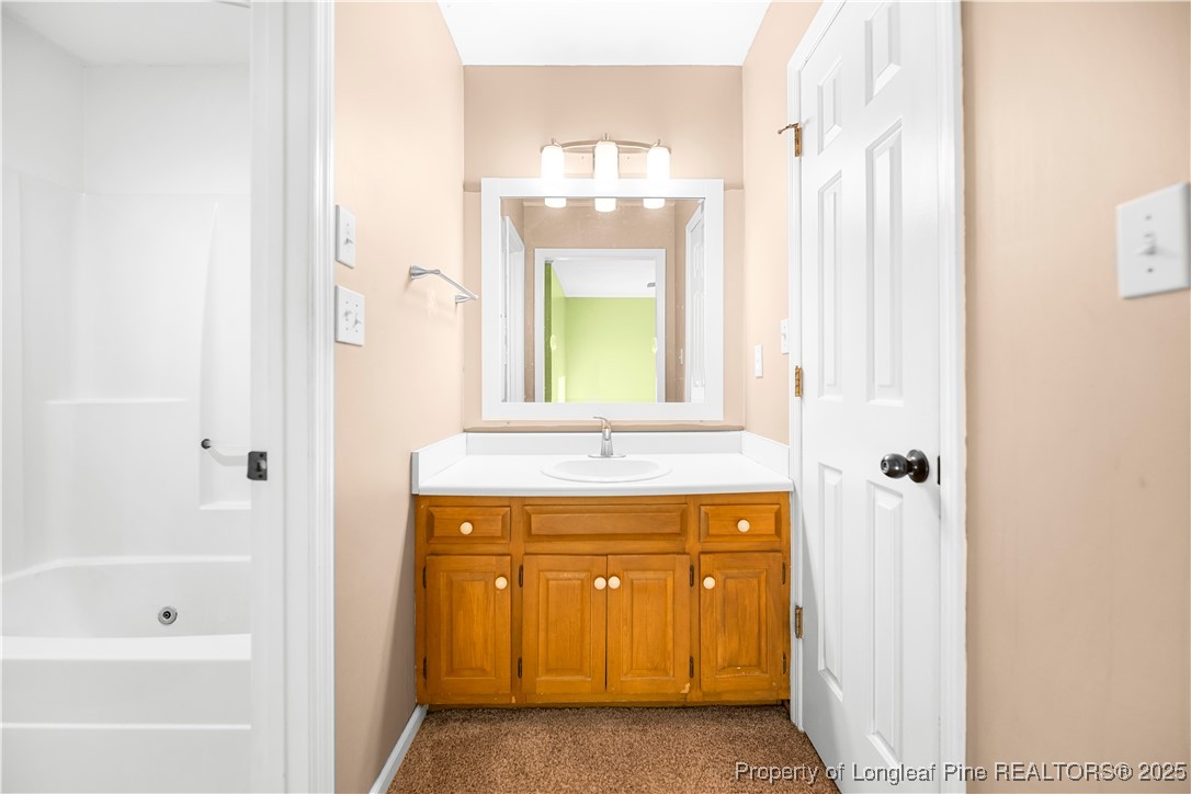 109 Ashton Place Spring Lake, NC 28390 - Photo 10 of 20 a bathroom with a sink a mirror and a bathtub