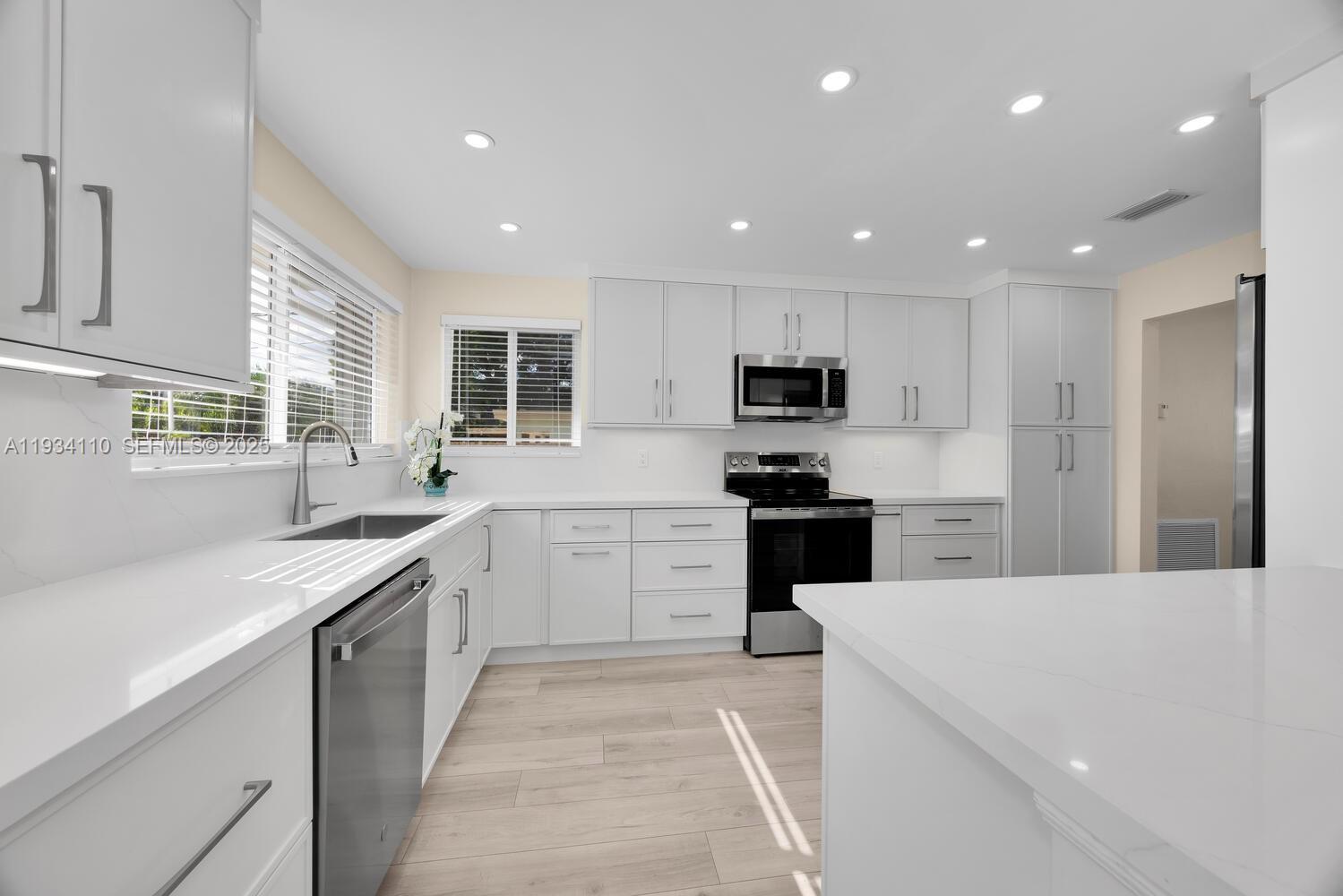 6110 Southwest 79th Street South Miami, FL 33143 - Photo 20 of 22 a kitchen with a sink a counter top space stainless steel appliances and cabinets