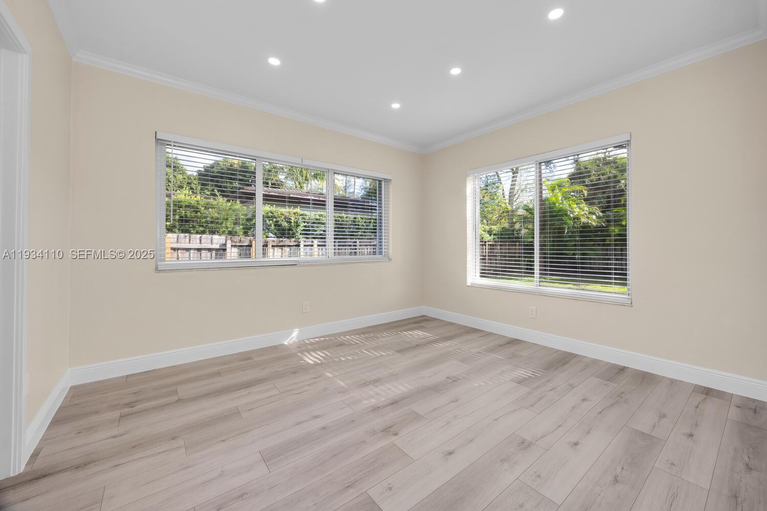 6110 Southwest 79th Street South Miami, FL 33143 - Photo 7 of 22 a view of an empty room with wooden floor and a window
