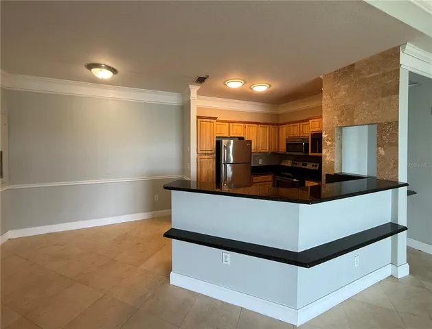 a view of living room with granite countertop a sink and a refrigerator