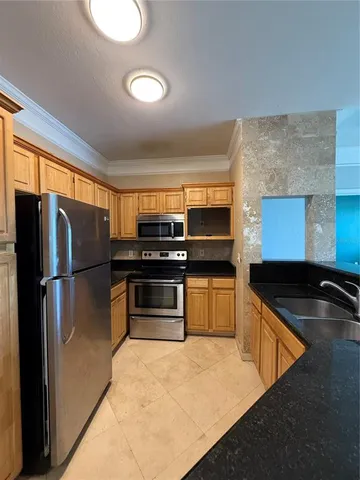a kitchen with granite countertop a refrigerator and a sink