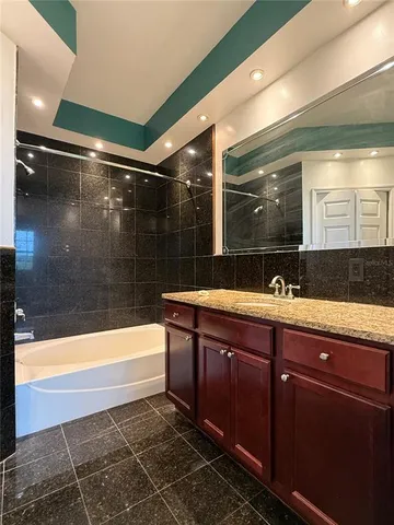 a bathroom with a sink mirror and bathtub