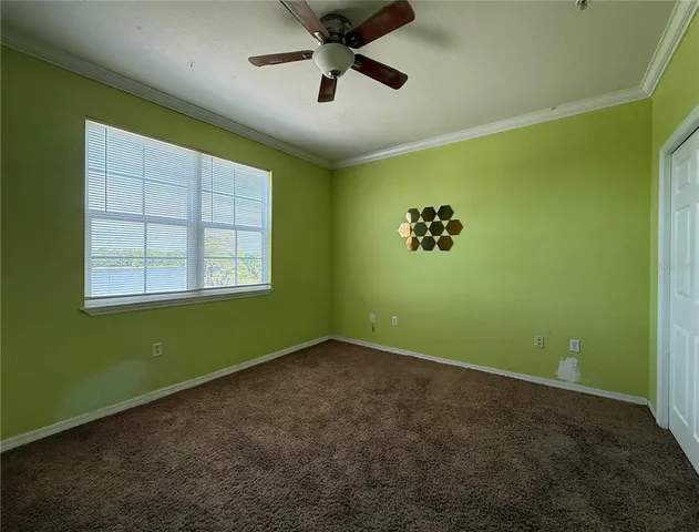 a view of an empty room with a window and a ceiling fan