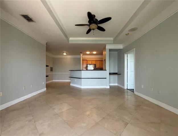 a view of a livingroom with a ceiling fan and a kitchen