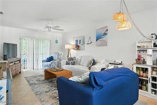 a living room with furniture a flat screen tv and kitchen view
