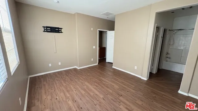 an empty room with wooden floor and a window