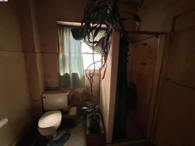 a bathroom with a toilet and a shower