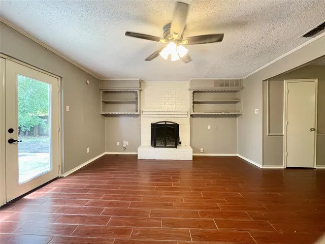a view of an empty room with a fireplace and a window