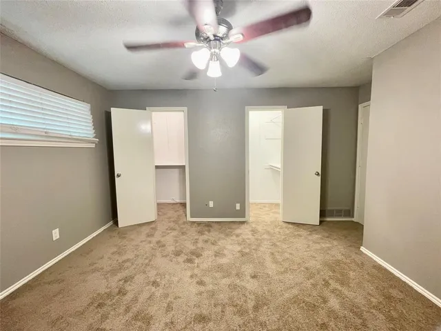 an empty room with fan and entrance