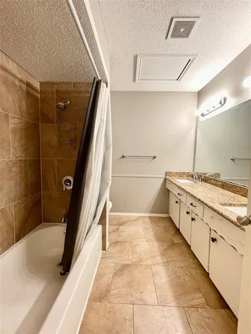 a bathroom with a granite countertop sink a toilet and shower