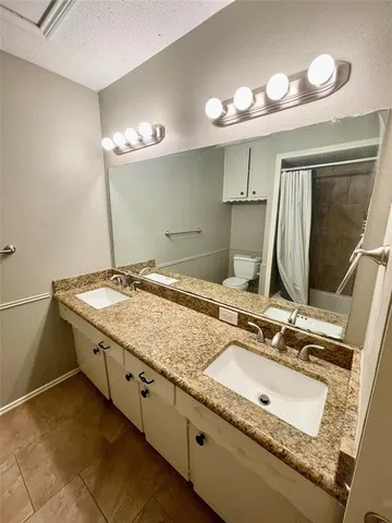 a bathroom with a granite countertop sink a mirror and shower