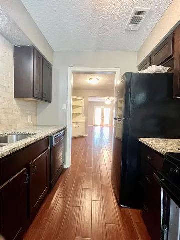 a kitchen with granite countertop stainless steel appliances and wooden cabinets