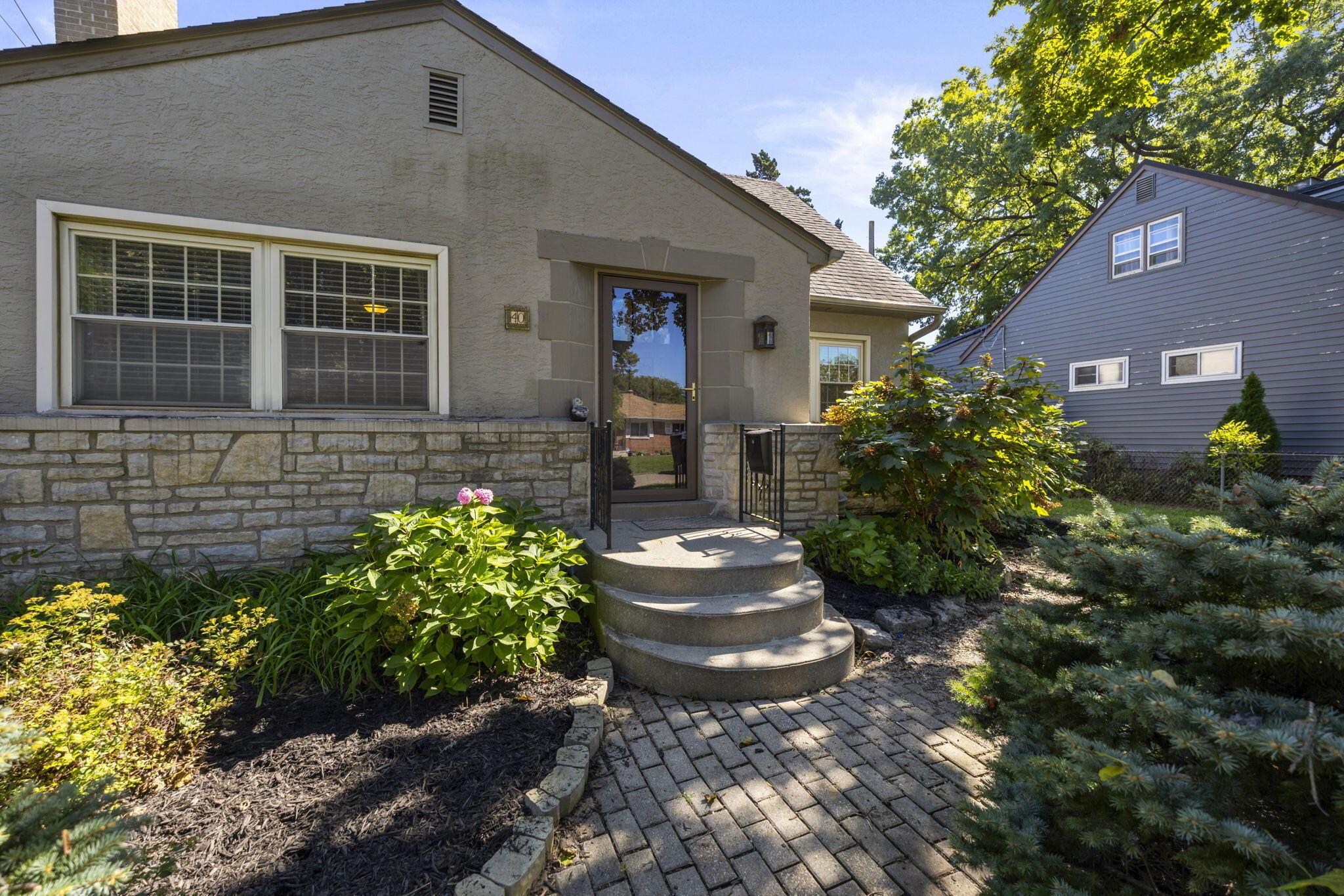 40 South Kellner Road Columbus, OH 43209 - Photo 56 of 57 Stucco exterior with stone accenting, multi-paned windows, a brick paver walkway, and mature landscaping