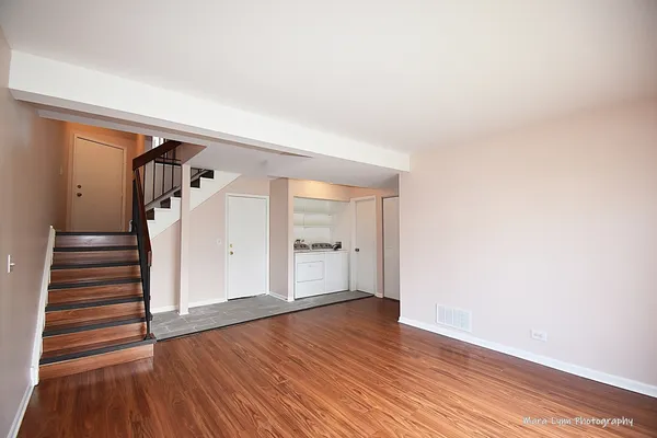 a view of empty room with wooden floor