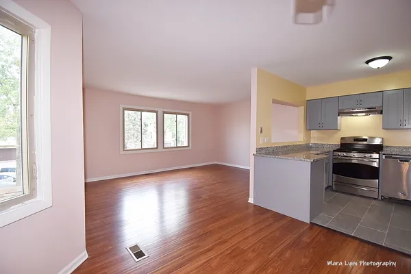 a kitchen with granite countertop wooden floors and a stove
