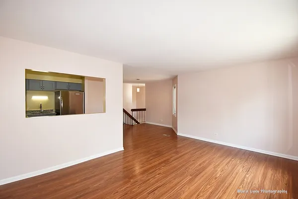 a view of an empty room with wooden floor