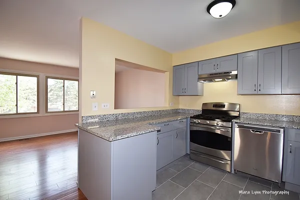 a kitchen with granite countertop cabinets stainless steel appliances and a sink
