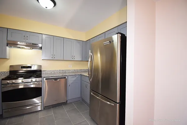a kitchen with granite countertop stainless steel appliances and wooden cabinets