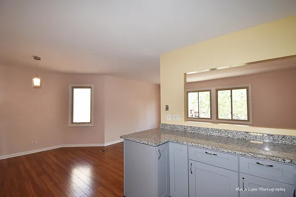 an empty room with wooden floor and window