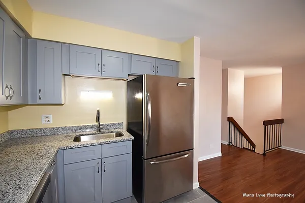 a kitchen with a refrigerator sink and cabinets