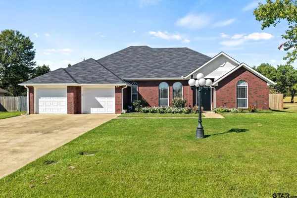 a front view of a house with a garden and yard