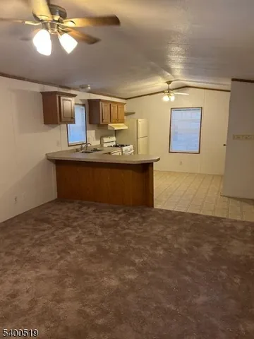 a view of kitchen and kitchen with granite countertop stove top oven