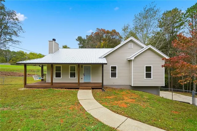 a view of a backyard with plants and large tree