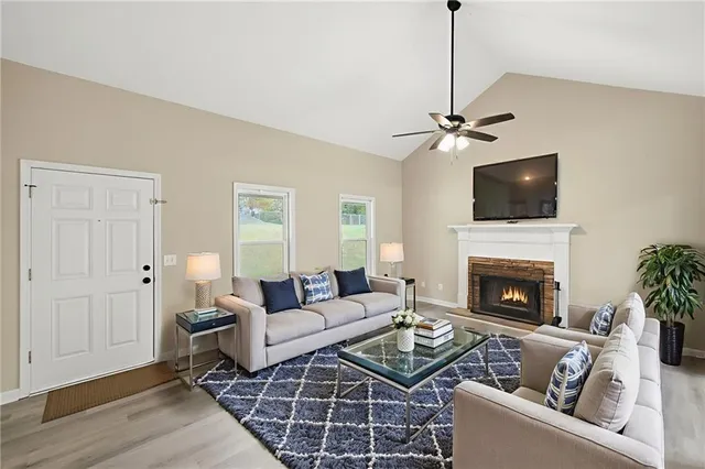 a view of an empty room with a fireplace and wooden floor
