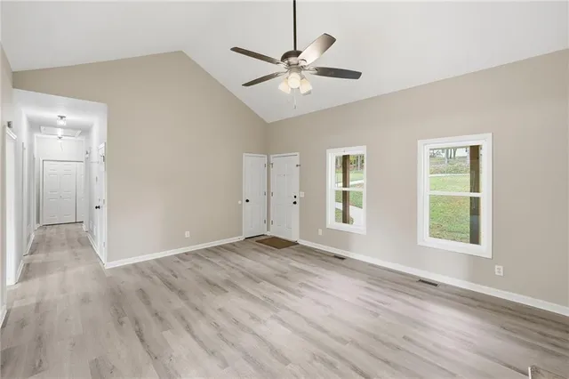 a large kitchen with stainless steel appliances granite countertop a stove a sink dishwasher a refrigerator and a wooden floor