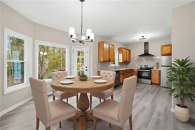 a kitchen with granite countertop a refrigerator a sink dishwasher a stove and white countertops with wooden floor