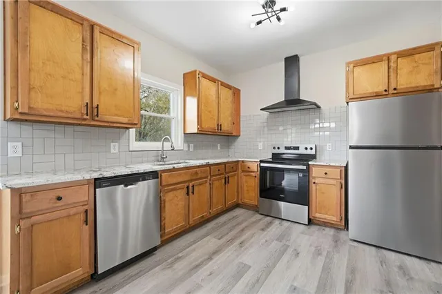 a kitchen with granite countertop a sink stove and cabinets