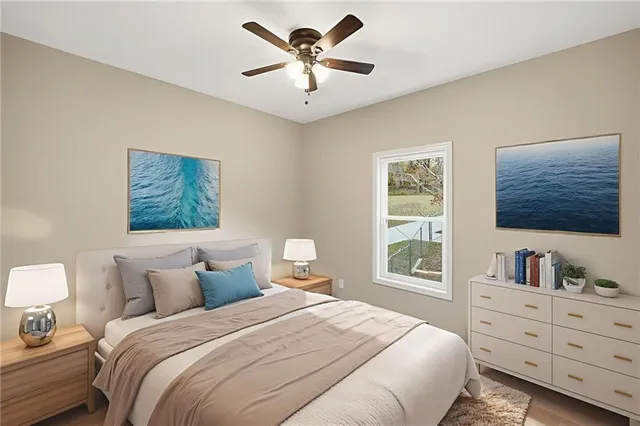 an empty room with wooden floor and ceiling fan