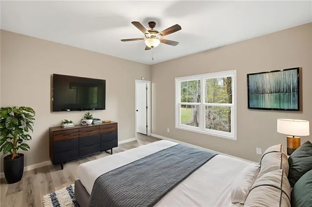 a bathroom with a granite countertop sink a toilet a mirror and bathtub