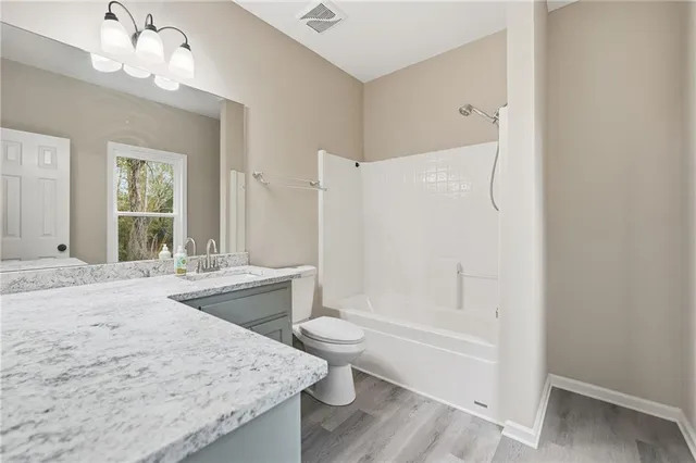 a bathroom with a granite countertop toilet sink and a mirror