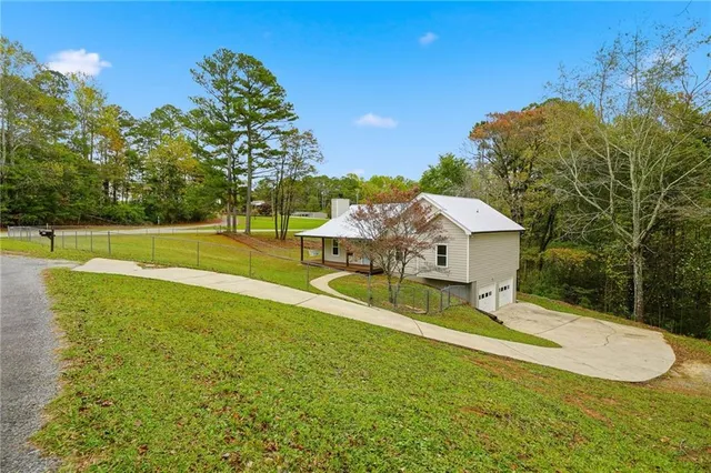 a house view with a garden and large trees
