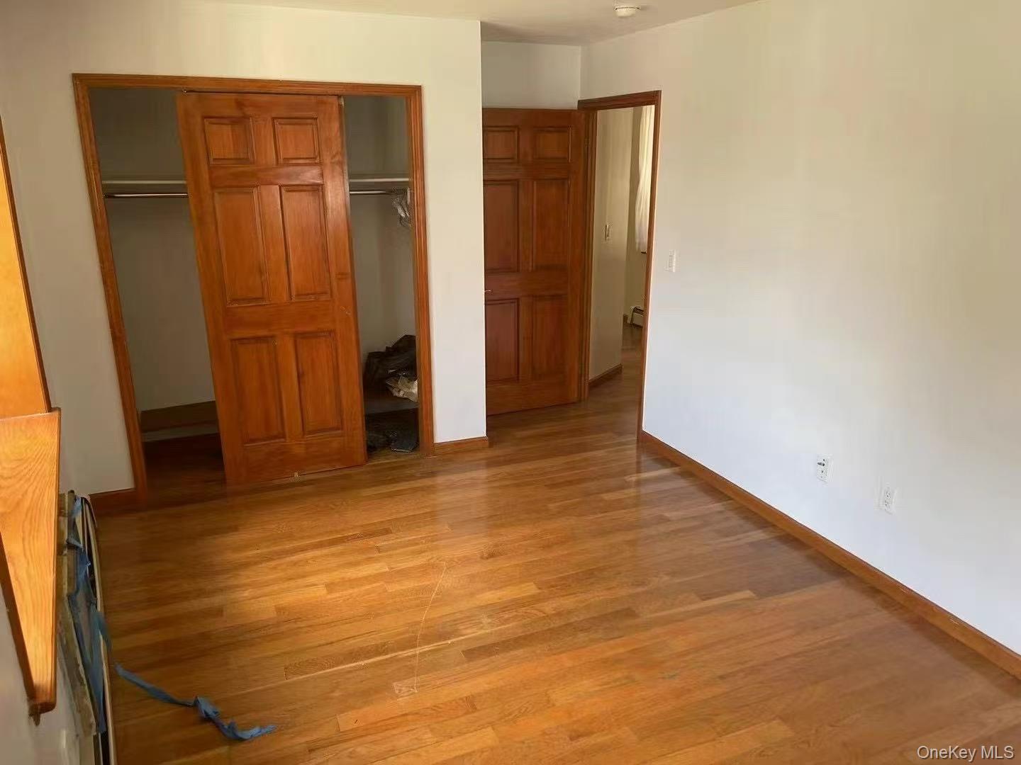 109-15 Westside Avenue, Unit 1A Queens, NY 11368 - Photo 6 of 8 Unfurnished bedroom with light wood-style floors and a closet