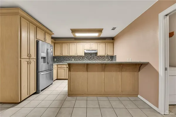 a kitchen with stainless steel appliances granite countertop a refrigerator and a stove top oven