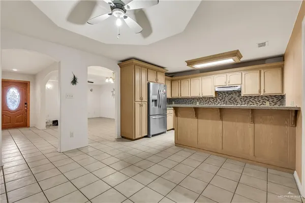 a large kitchen with stainless steel appliances granite countertop a refrigerator and a stove top oven