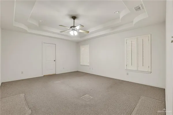 an empty room with a ceiling fan and a window