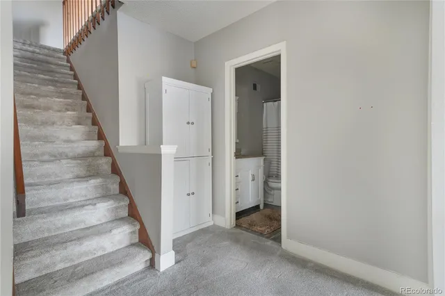 a bathroom with a granite countertop toilet and a sink