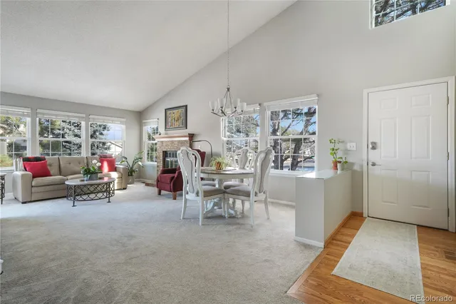 a living room with furniture and a dining table with wooden floor