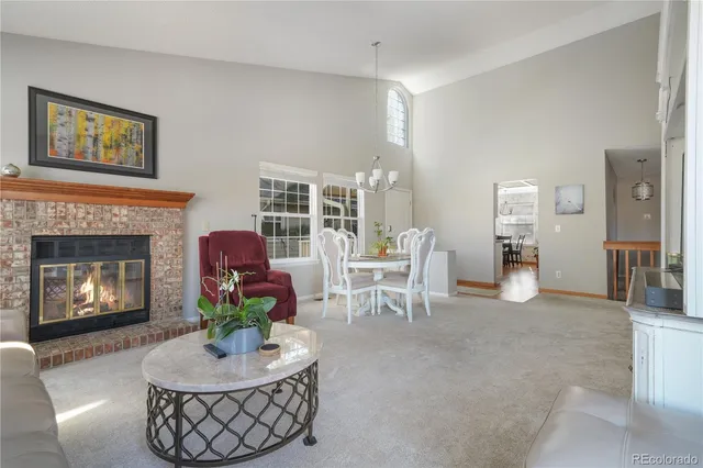 a living room with furniture a fireplace and a table